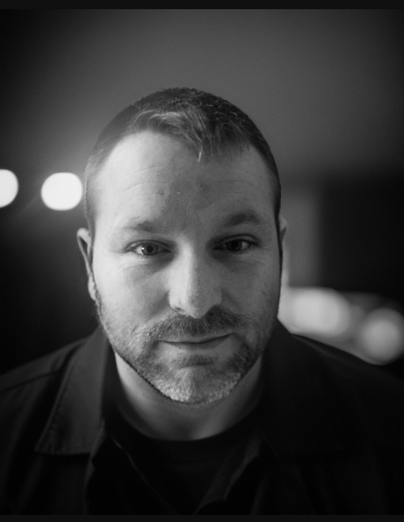 Black and white portrait of a man smiling.