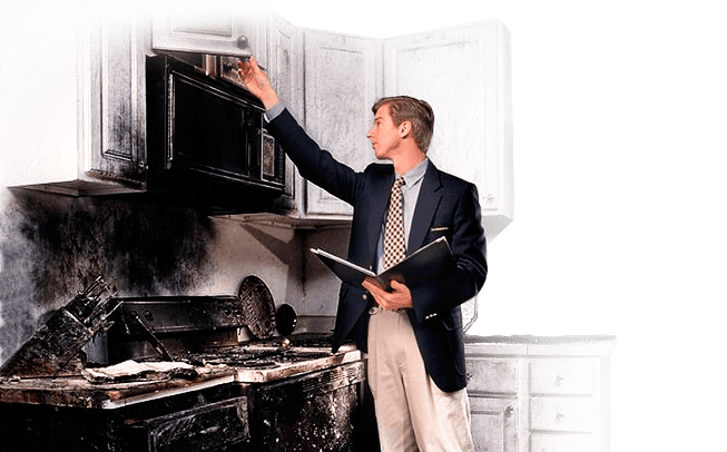 Inspector examining fire-damaged kitchen cabinet.